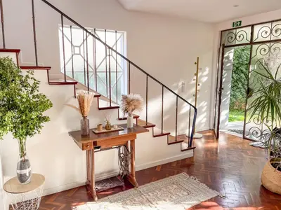 a staircase in a home with a wooden table and plants at Sunny Double Room in 4BR Villa with AC, Sea View Balcony, Workspace in Funchal