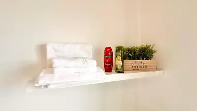 a white shelf with towels and a bottle of shampoo at Edna 2 in Funchal