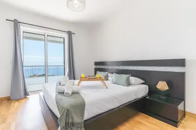 a bedroom with a large bed and a large window at Palm Paradise Villa by AH in Câmara de Lobos