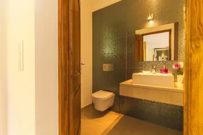 a bathroom with a sink and a toilet and a mirror at Palm Paradise Villa by AH in Câmara de Lobos