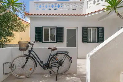 a bike parked in front of a white house at Barlavento by An Island Apart in Porto Santo