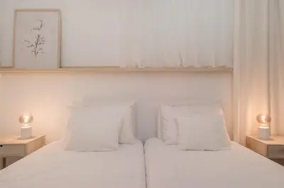 a bedroom with a white bed with white pillows at Barlavento by An Island Apart in Porto Santo