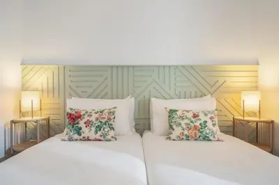 a bedroom with a white bed with two pillows at Barlavento by An Island Apart in Porto Santo