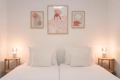 a bedroom with two white beds with two lamps at Barlavento by An Island Apart in Porto Santo