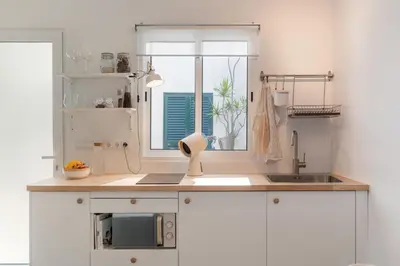 a kitchen with white cabinets and a window and a sink at Barlavento by An Island Apart in Porto Santo