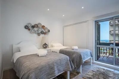 two beds in a room with a window at Piornais Apartment by Holiday Rental Madeira in Funchal