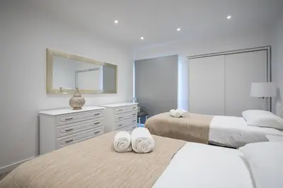 a bedroom with two beds and a mirror at Piornais Apartment by Holiday Rental Madeira in Funchal