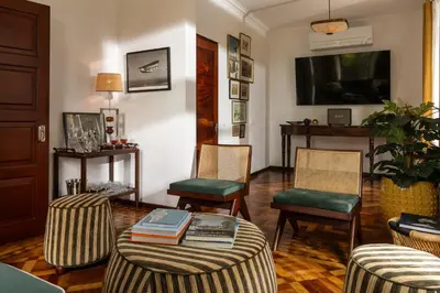 a living room with chairs and a table and a tv at Eden Funchal by LovelyStay in Funchal