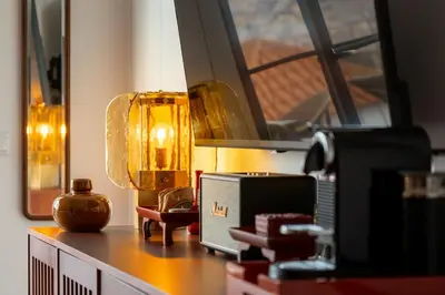 a table with a lamp and other items on it at Eden Funchal by LovelyStay in Funchal