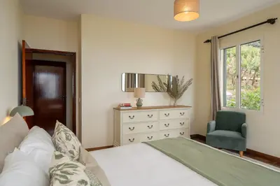 a bedroom with a bed and a chair and a dresser at Casa Imaculado Coração by An Island Apart in Funchal