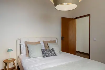 a bed with white sheets and pillows in a bedroom at Casa Imaculado Coração by An Island Apart in Funchal