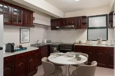 a kitchen with wooden cabinets and a table and chairs at Casa Imaculado Coração by An Island Apart in Funchal