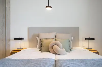 a bed with a hat on it with two lamps at Savoy Monumentalis IV by An Island Apart in Funchal