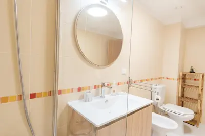 a bathroom with a sink and a toilet and a mirror at GuestReady - O Cantinho dos Pestanas in Caniço