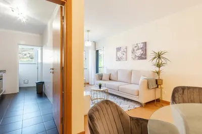 a living room with a white couch and a table at GuestReady - O Cantinho dos Pestanas in Caniço