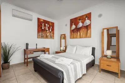 a bedroom with a bed and a table and a mirror at Coastal Terrace Apartment in Lagos