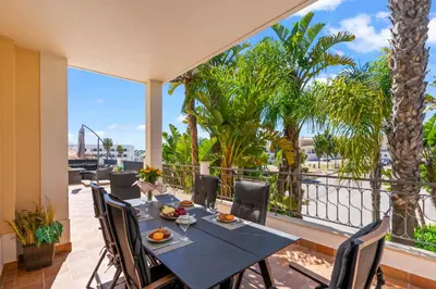 a dining table on a balcony with a view of the ocean at Coastal Terrace Apartment in Lagos