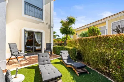 a patio with chaisers and chairs in a backyard at Coastal Charm Apartment in Lagos