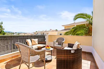 a patio with wicker chairs and tables on a balcony at Coastal Charm Apartment in Lagos