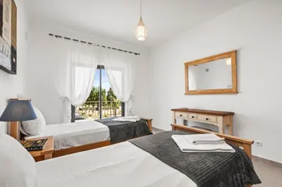 two beds in a room with a window at Coastal Charm Apartment in Lagos