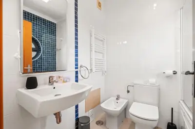 a white bathroom with a sink and a toilet at Coastal Charm Apartment in Lagos