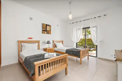 a bedroom with two beds and a table at Coastal Charm Apartment in Lagos
