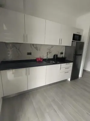 a kitchen with white cabinets and black counter tops at Vila Ramos I in Funchal