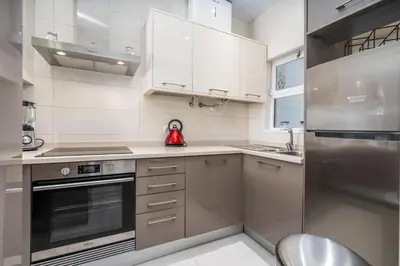 a kitchen with white cabinets and a red appliance at Blue Horizon Apartment in Luz