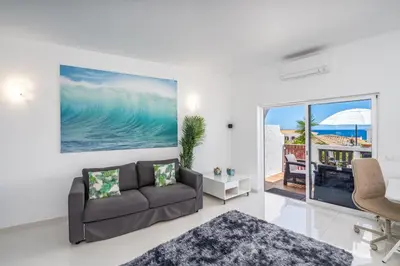 a living room with a couch and a view of the ocean at Blue Horizon Apartment in Luz