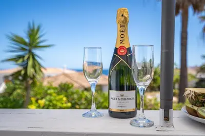 a bottle of wine and two wine glasses on a table at Blue Horizon Apartment in Luz