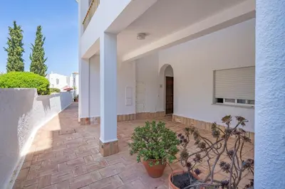 a courtyard of a white house with a potted plant at Blue Horizon Apartment in Luz