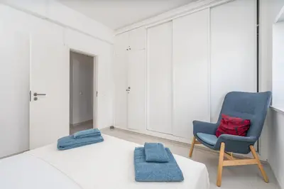 a bedroom with a bed and a blue chair at Blue Horizon Apartment in Luz