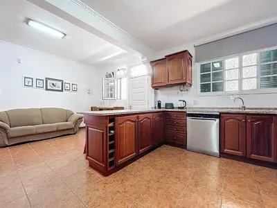 a large kitchen with wooden cabinets and a couch at Villa Santa Luzia 2 by Atlantic Holiday in Santa Luzia