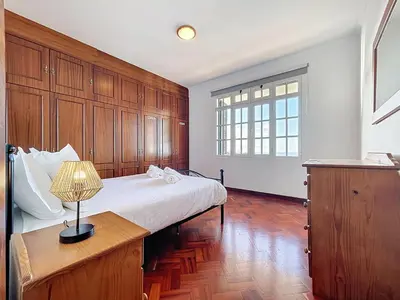 a bedroom with a bed and a table with a lamp at Villa Santa Luzia 2 by Atlantic Holiday in Santa Luzia