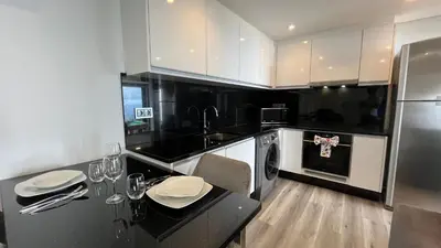 a kitchen with white cabinets and a black counter top at The View-Neves in Funchal