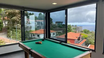 a pool table in a room with large windows at The View-Neves in Funchal