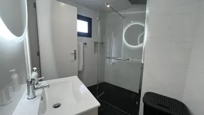 a white bathroom with a sink and a shower at The View-Neves in Funchal