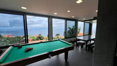 a pool table in a room with a view of the ocean at The View-Neves in Funchal