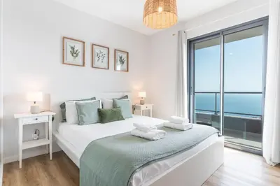 a bedroom with a bed and a large window at Atlantic Haven by Atlantic Holiday in Caniço