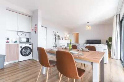 a kitchen and dining room with a wooden table and chairs at Atlantic Haven by Atlantic Holiday in Caniço