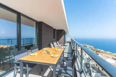 a balcony with chairs and a view of the ocean at Atlantic Haven by Atlantic Holiday in Caniço