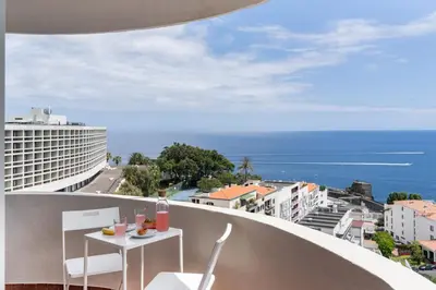 a balcony with a table and chairs and the ocean at Olimpo I by An Island Apart in Funchal