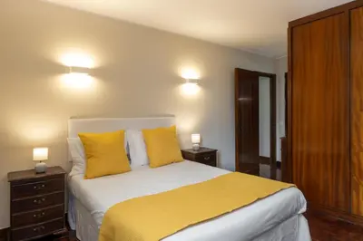 a bedroom with a large bed with yellow pillows at Olimpo I by An Island Apart in Funchal