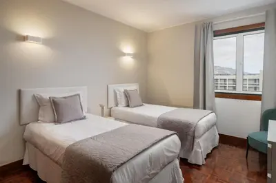 a hotel room with two beds and a window at Olimpo I by An Island Apart in Funchal