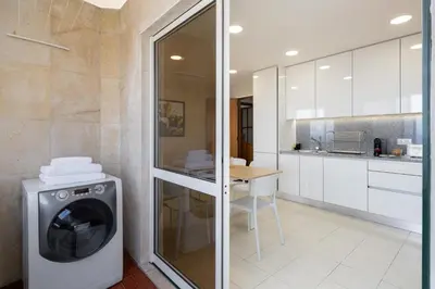 a kitchen with a washing machine in a room at Olimpo I by An Island Apart in Funchal