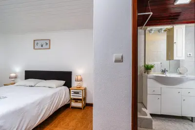 a bedroom with a large white bed and a night stand at Casa Santos- Arco da Calheta in Arco da Calheta