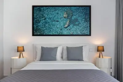a bedroom with a white bed and two lamps at Calheta Hills II by An Island Apart in Estreito da Calheta