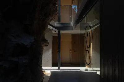 a room with a stone wall next to a building at Calheta Hills II by An Island Apart in Estreito da Calheta