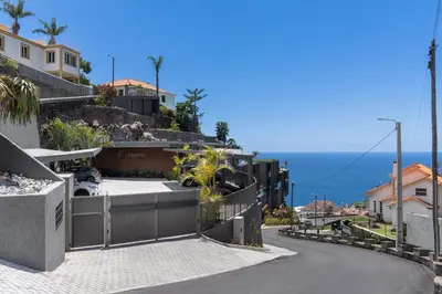 a street with houses and the ocean in the background at Calheta Hills II by An Island Apart in Estreito da Calheta