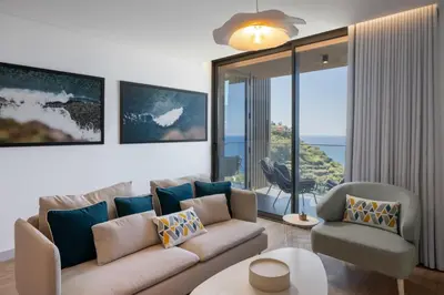 a living room with a couch and chairs and a large window at Calheta Hills II by An Island Apart in Estreito da Calheta